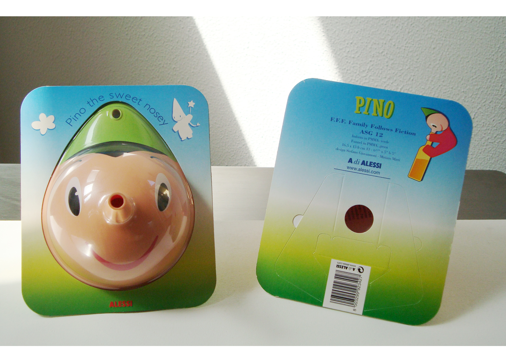 Immagine per il libro "Design in Cucina" dell'imbuto con il viso di Pinocchio e il relativo packaging trasparente per l'esposizione nei negozi. Fronte e retro. Produzione Alessi 1998. Design di Giovannoni e Mirri.